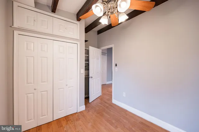 a view of an empty room with a chandelier fan