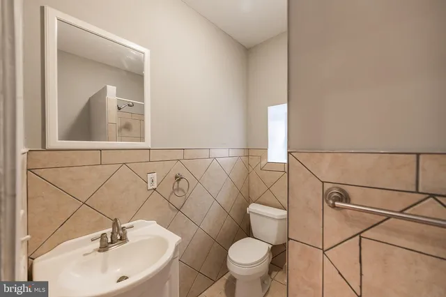 a bathroom with a sink mirror vanity and toilet