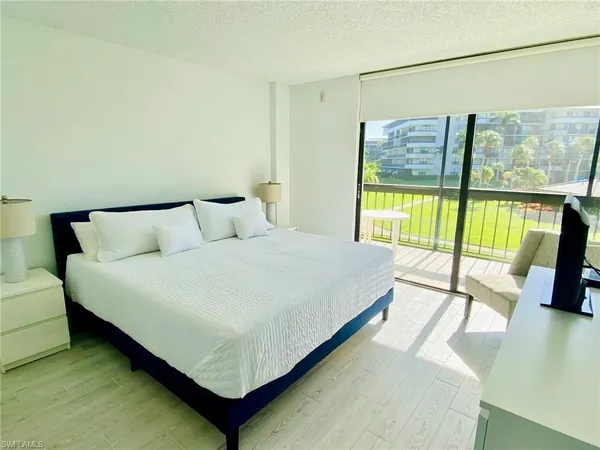 a bedroom with a bed and a large window
