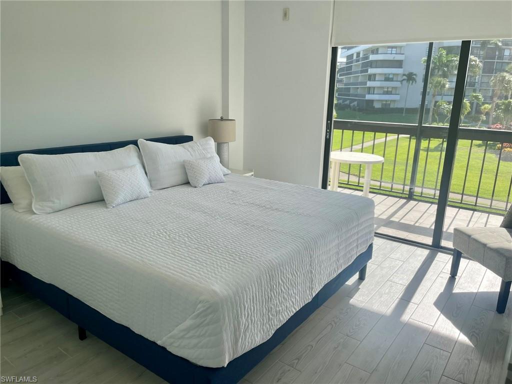 601 Seaview Court, Unit C208 Marco Island, FL 34145 - Photo 8 of 16 a large bed sitting in a bedroom next to a window