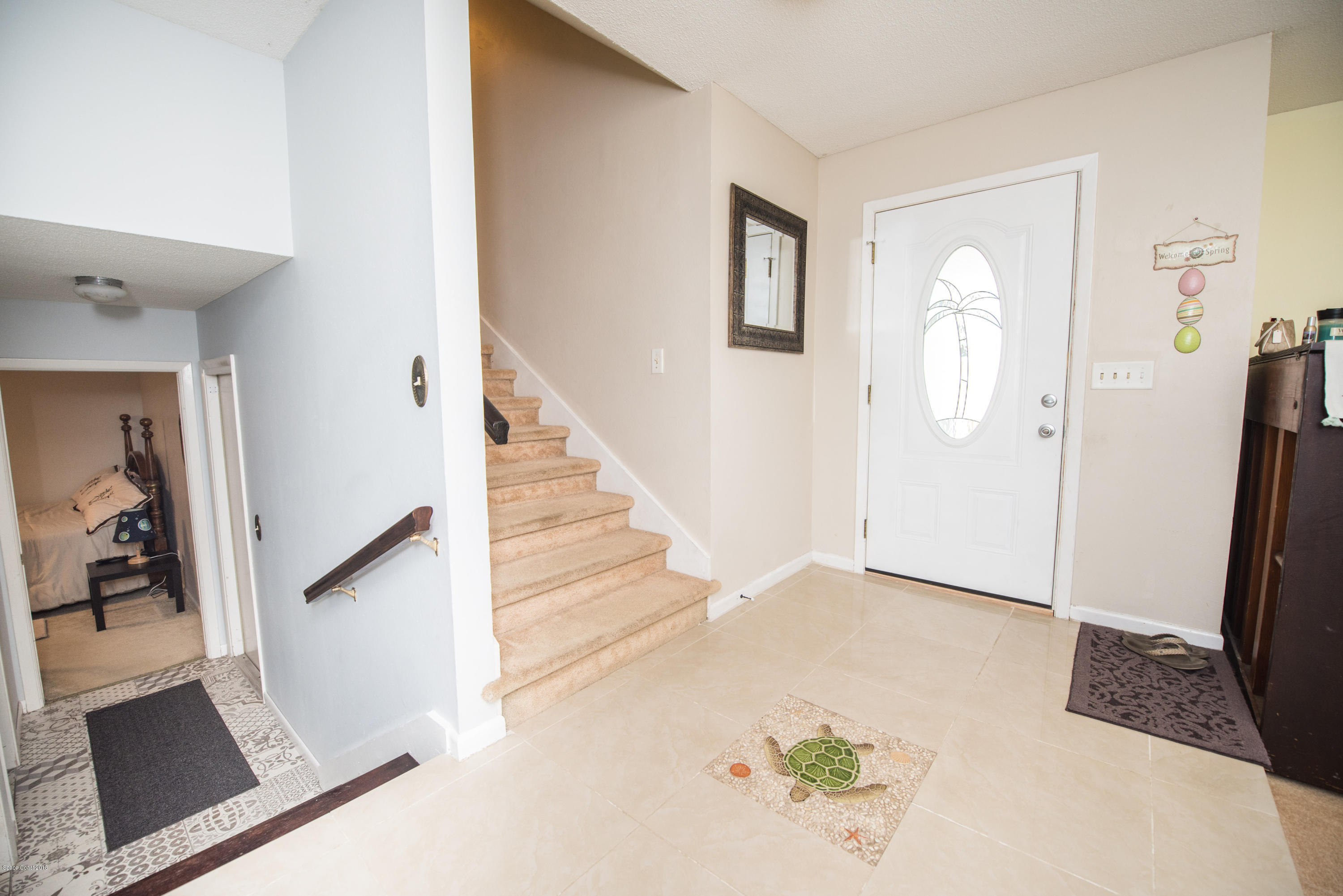 1023 Palmer Road Rockledge, FL 32955 - Photo 12 of 24 wooden floor with white walls and stairs