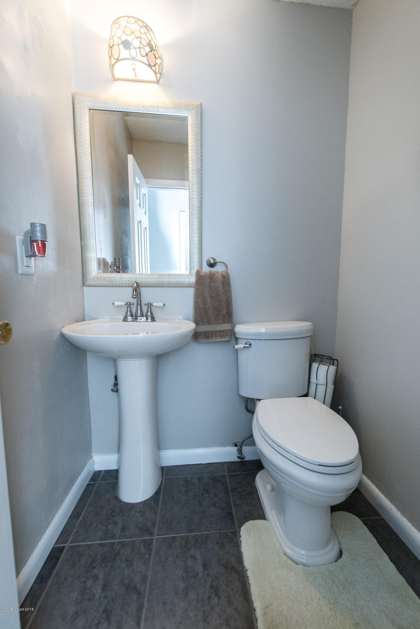 1023 Palmer Road Rockledge, FL 32955 - Photo 14 of 24 a bathroom with a sink toilet and mirror