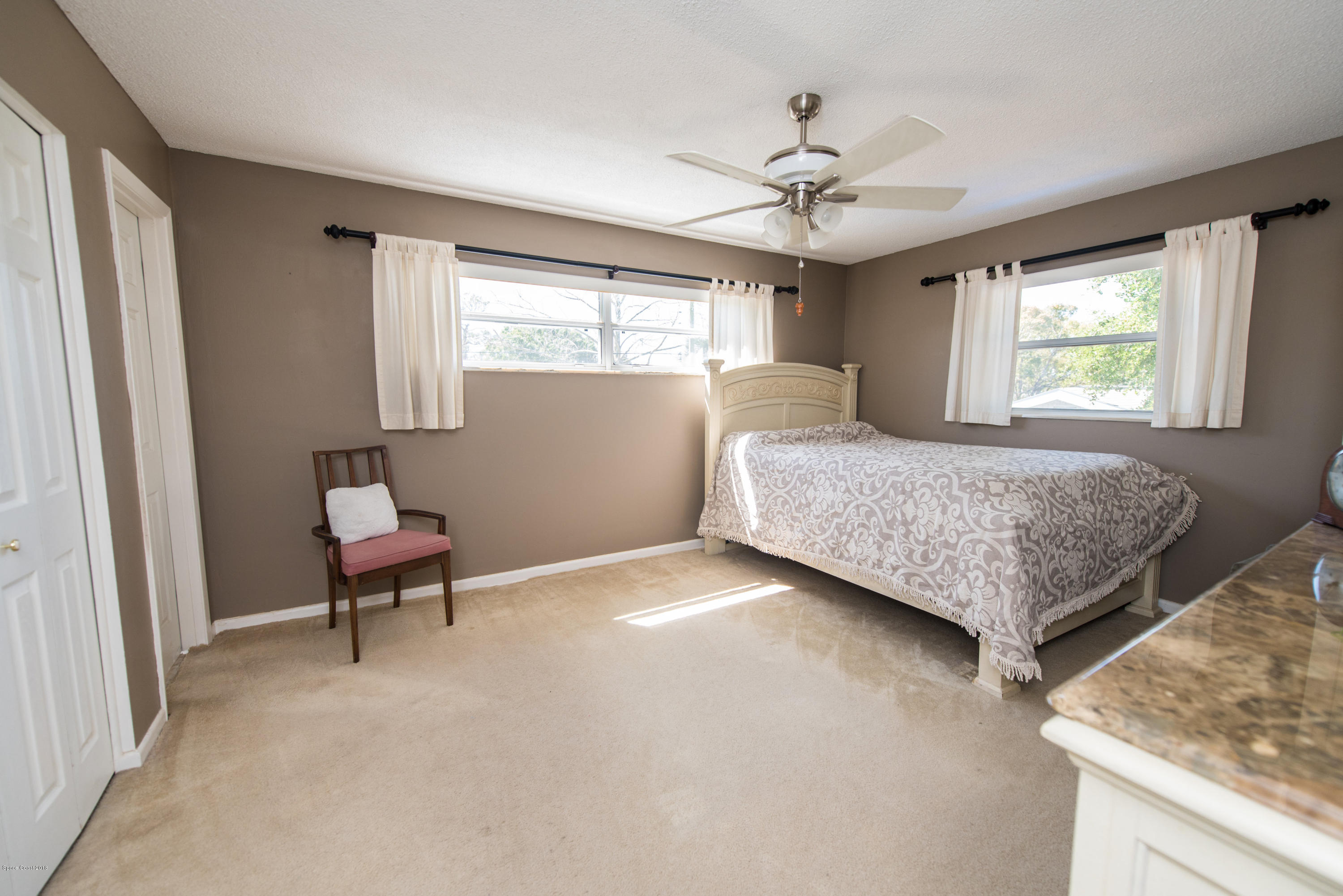 1023 Palmer Road Rockledge, FL 32955 - Photo 15 of 24 a bedroom with a bed and a chandelier