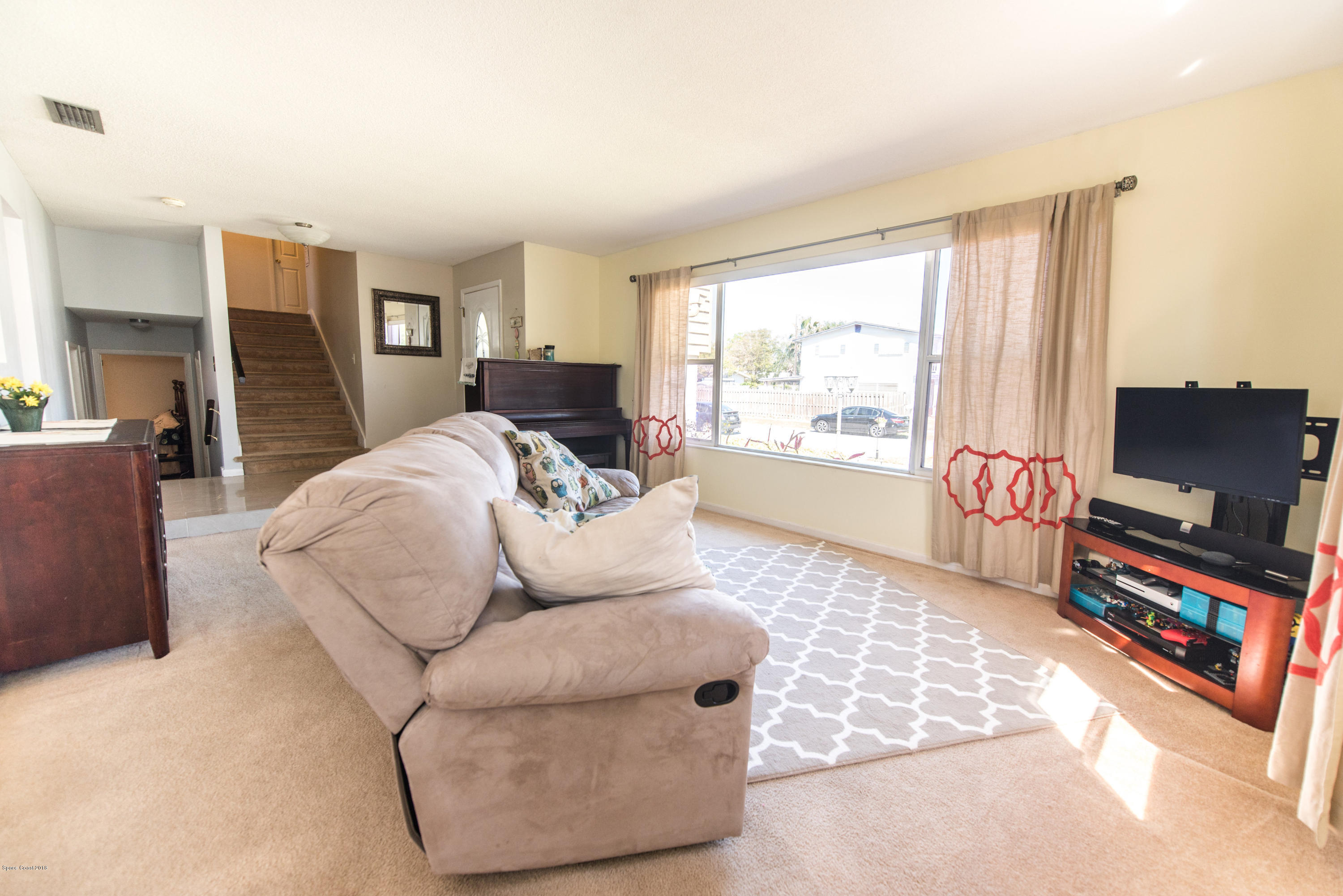 1023 Palmer Road Rockledge, FL 32955 - Photo 7 of 24 a living room with furniture a flat screen tv and a large window