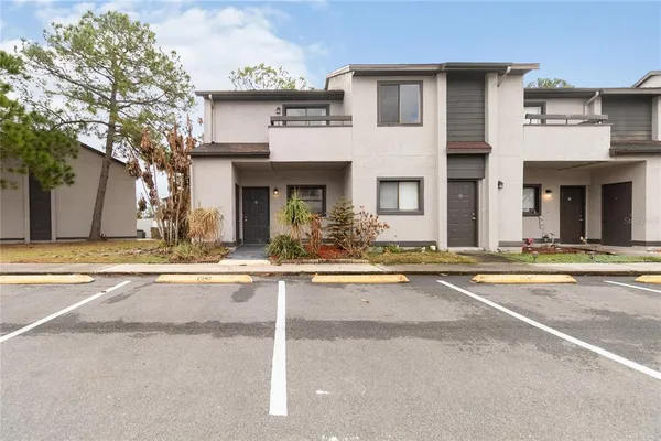 a view of a white house with a large windows and a large tree