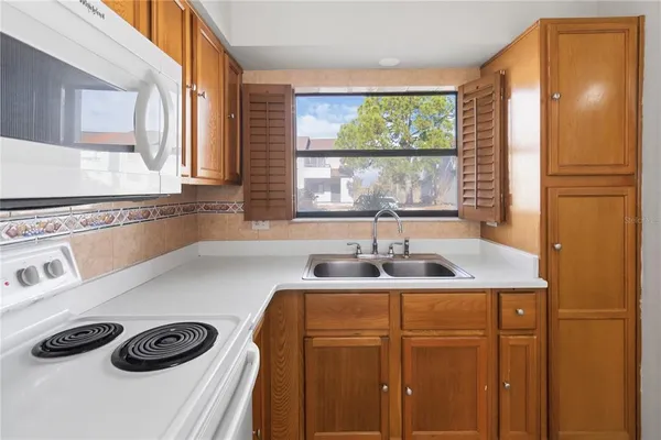 a kitchen with a sink a stove and a window