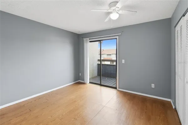 an empty room with closet and a chandelier fan