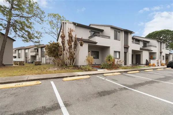 a view of a white house with a large tree