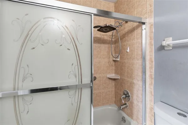 a bathroom with a glass shower door and mirror