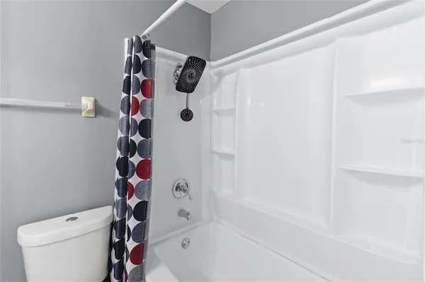 a bathroom with a toilet and a shower curtain