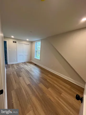 a view of empty room with window and wooden floor