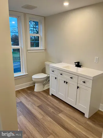 a bathroom with a sink a toilet and a window