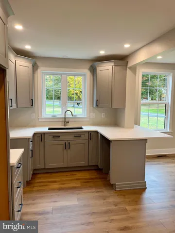 a kitchen with a sink cabinets and wooden floor
