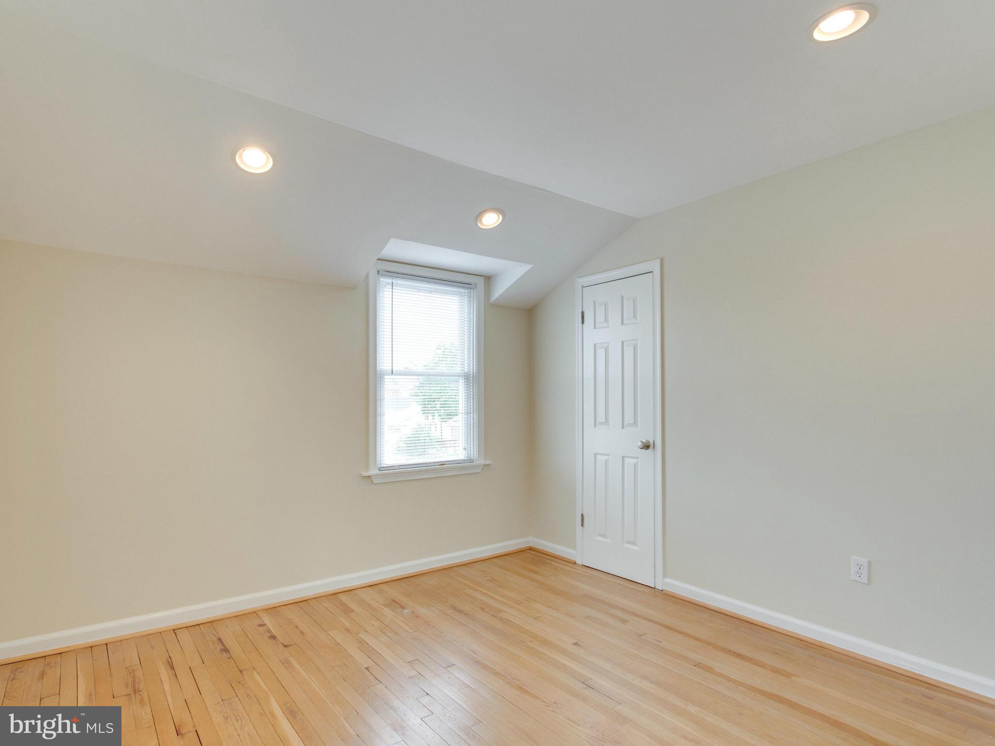 5131 Sheriff Road Northeast Washington, DC 20019 - Photo 11 of 29 an empty room with wooden floor and windows