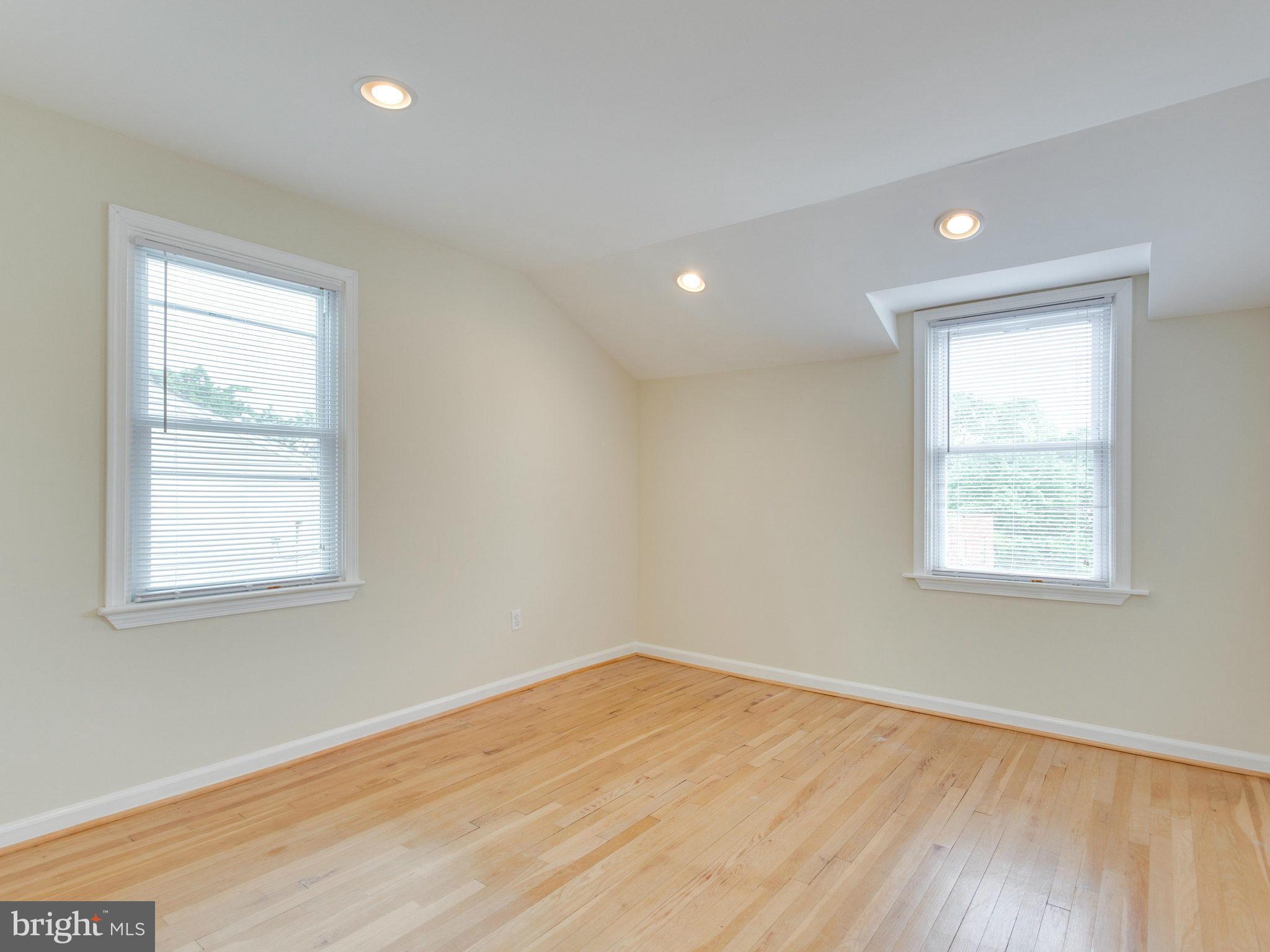 5131 Sheriff Road Northeast Washington, DC 20019 - Photo 13 of 29 an empty room with wooden floor and windows