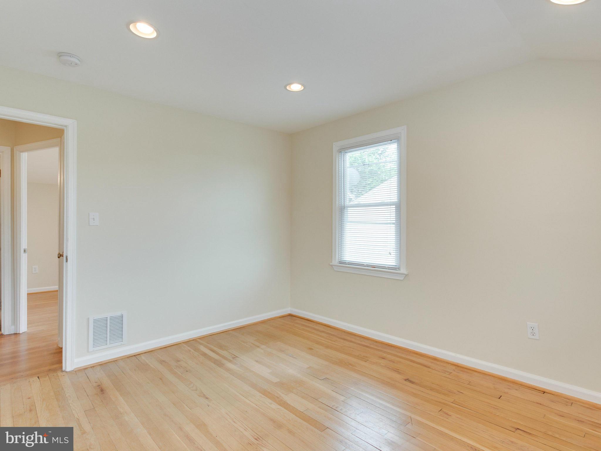 5131 Sheriff Road Northeast Washington, DC 20019 - Photo 14 of 29 an empty room with wooden floor and windows