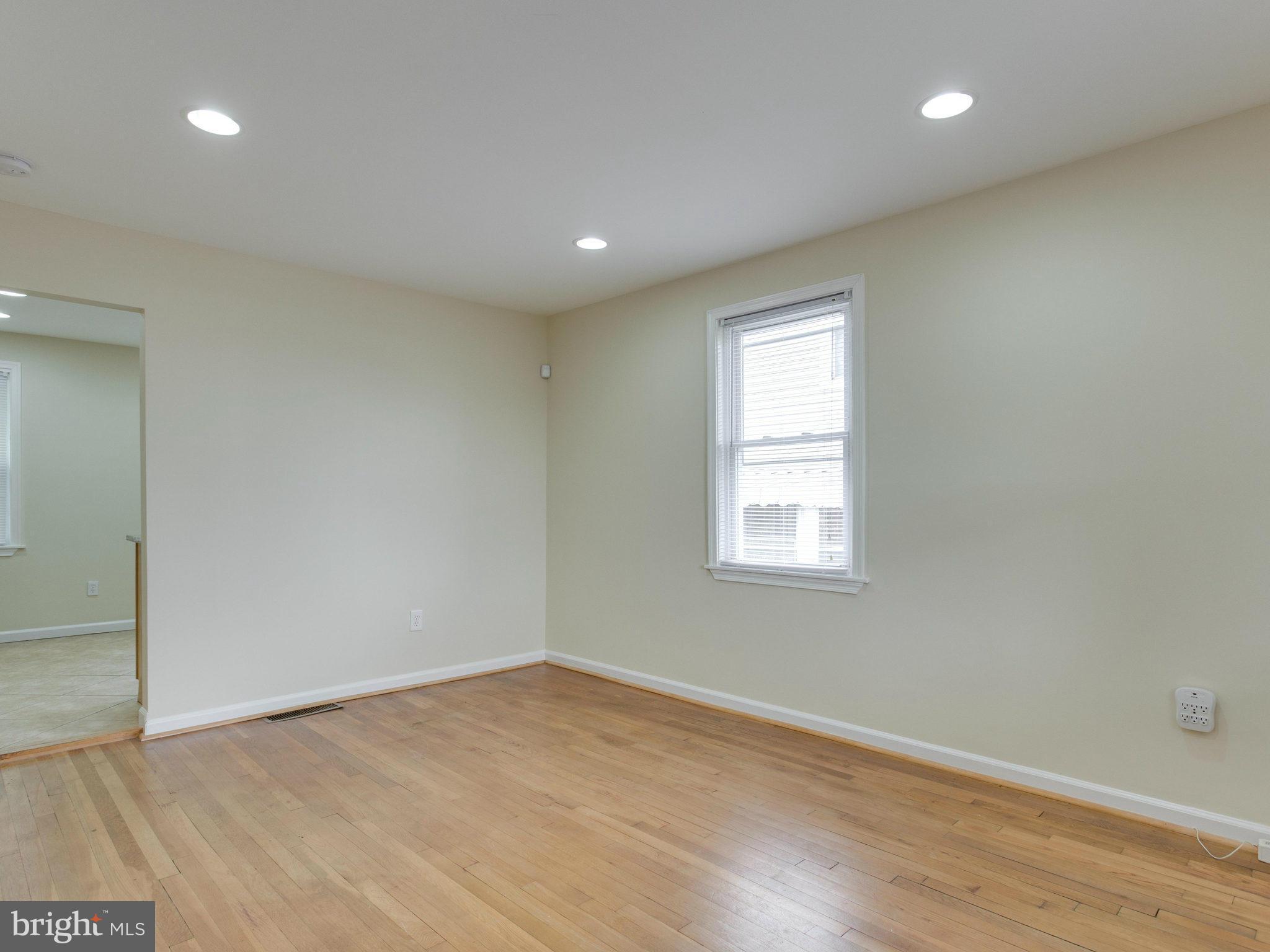 5131 Sheriff Road Northeast Washington, DC 20019 - Photo 4 of 29 an empty room with wooden floor and windows