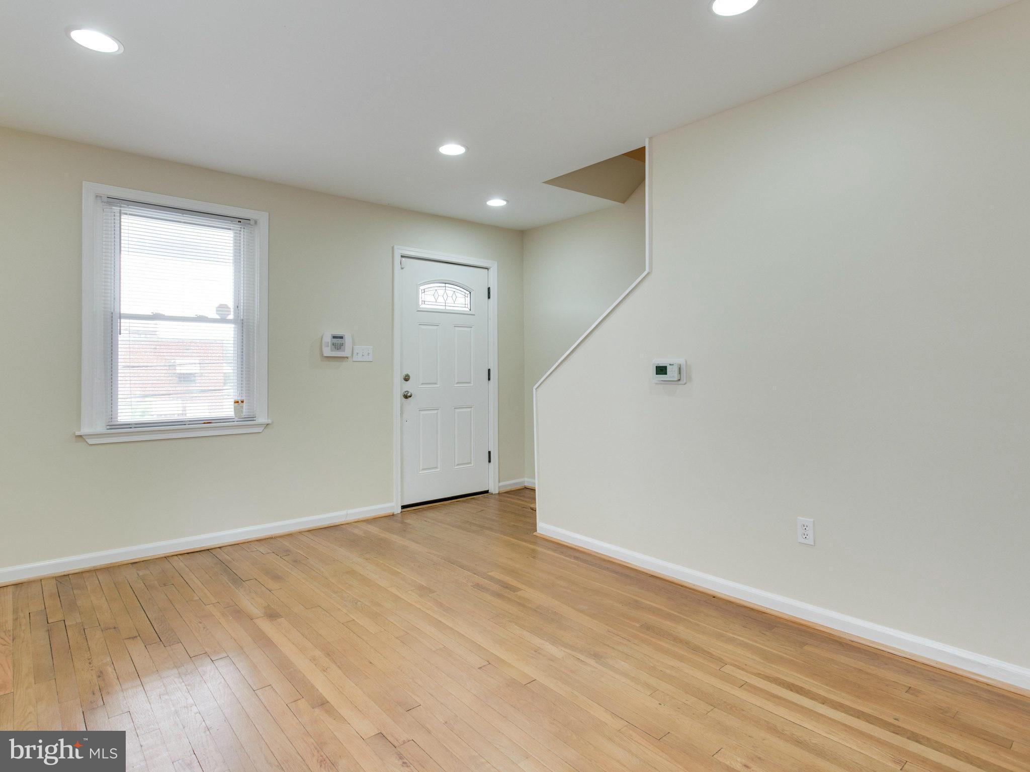 5131 Sheriff Road Northeast Washington, DC 20019 - Photo 6 of 29 an empty room with wooden floor and windows