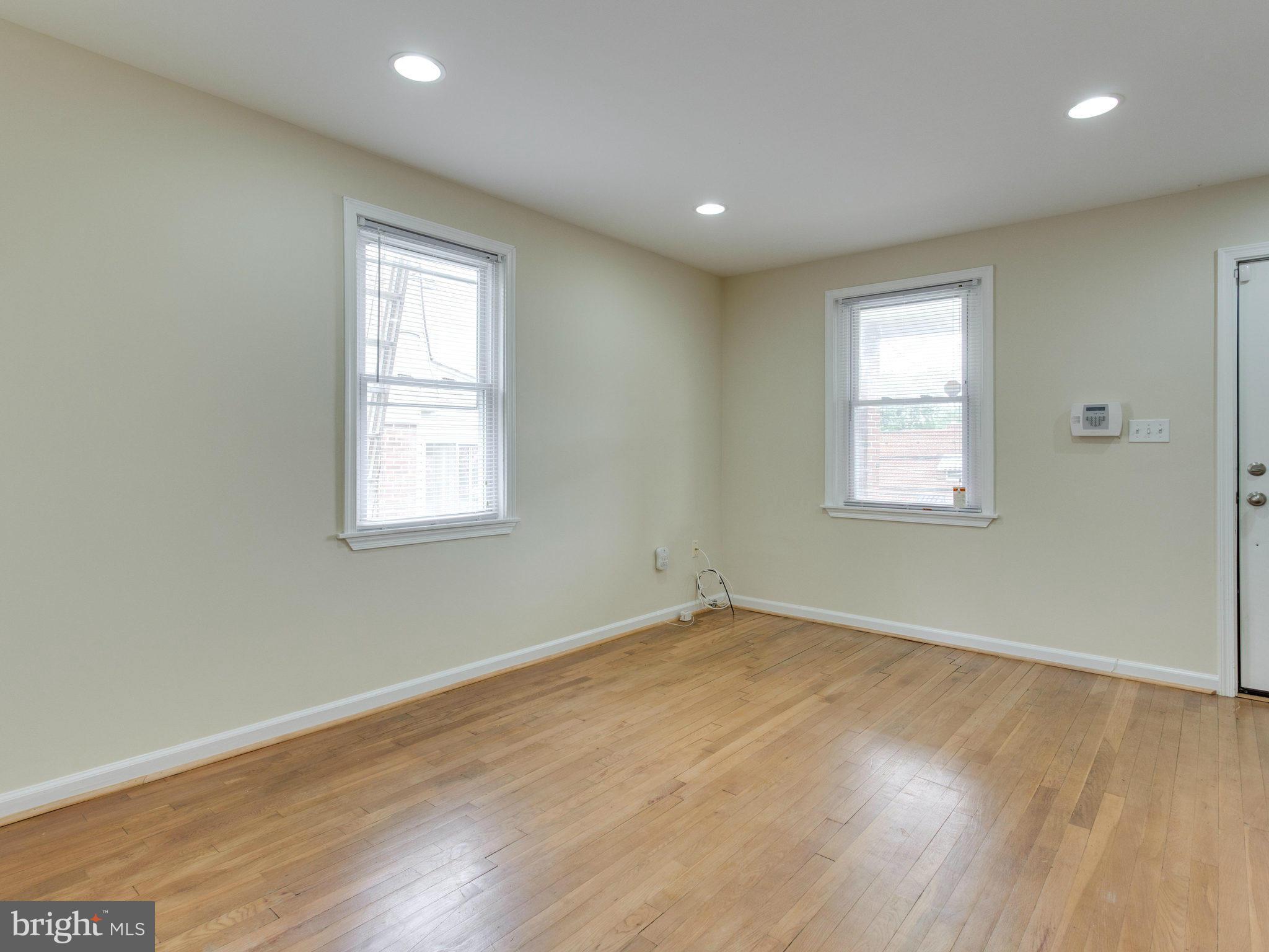 5131 Sheriff Road Northeast Washington, DC 20019 - Photo 7 of 29 an empty room with wooden floor and windows