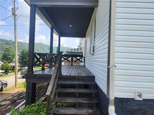 a view of a balcony with chairs and wooden floor