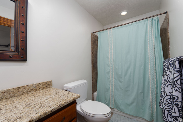 687 South 2080th Street East Springville, UT 84663 - Photo 52 of 149 Bathroom featuring a built-in wood vanity with a stone countertop, a white toilet, and a shower with tile surround