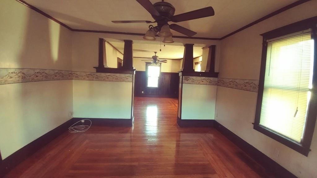 124 Phoenix Terrace Springfield, MA 01104 - Photo 6 of 17 a view of a room with wooden floor a ceiling fan and windows