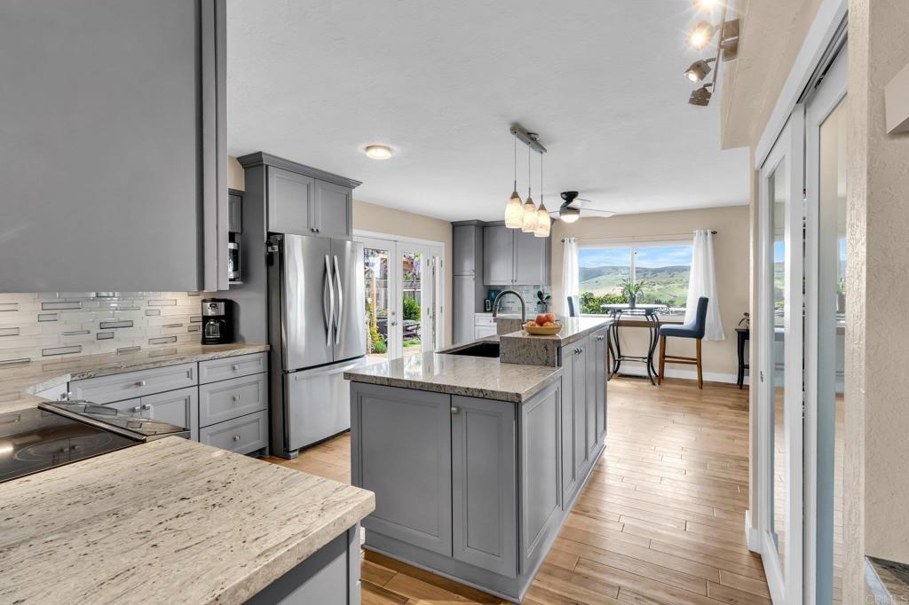 13501 Melissa Lane Poway, CA 92064 - Photo 12 of 62 a kitchen with kitchen island granite countertop a sink stove and refrigerator