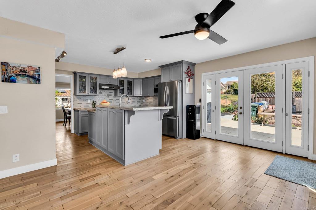13501 Melissa Lane Poway, CA 92064 - Photo 13 of 62 a view of kitchen with stainless steel appliances kitchen island a stove a refrigerator a sink dishwasher and a fireplace with wooden floor