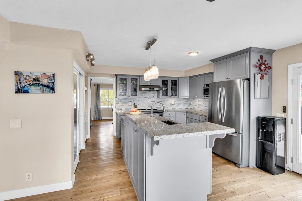 13501 Melissa Lane Poway, CA 92064 - Photo 14 of 62 a kitchen with stainless steel appliances granite countertop a refrigerator a sink dishwasher a stove and a refrigerator with wooden floor
