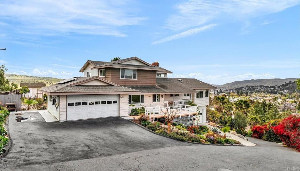 13501 Melissa Lane Poway, CA 92064 - Photo 2 of 62 a view of a white house with a yard and table and chairs under an umbrella