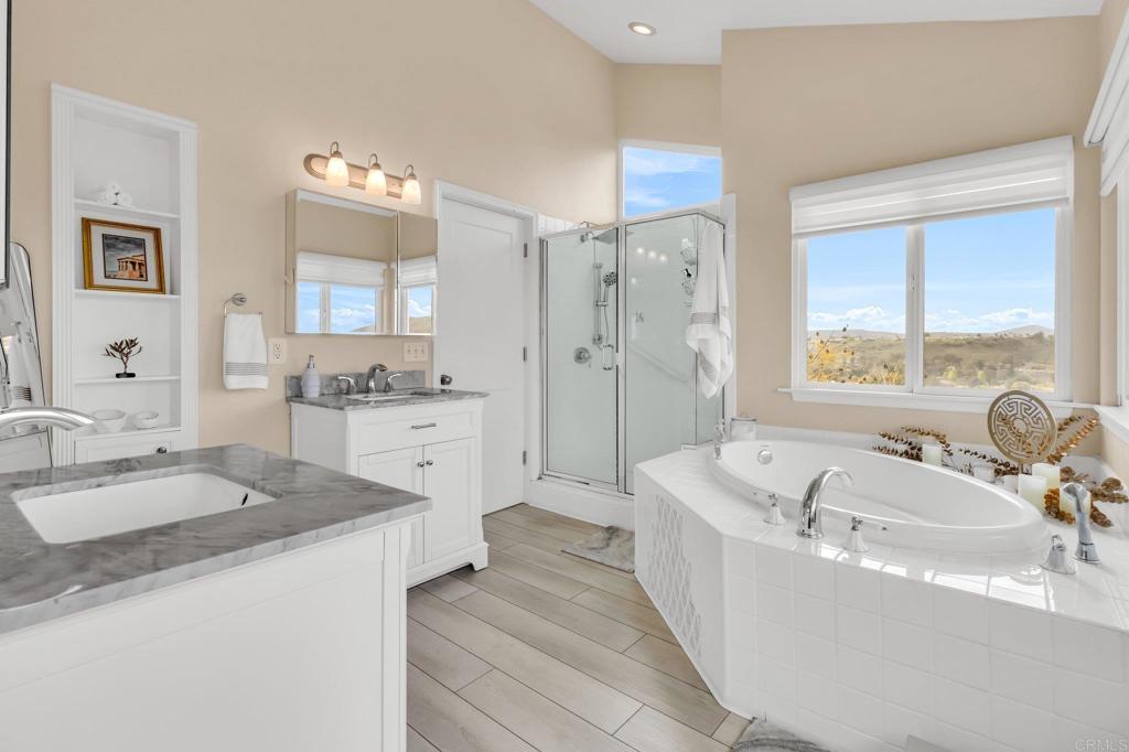 13501 Melissa Lane Poway, CA 92064 - Photo 28 of 62 a spacious bathroom with sinks a bathtub a mirror a vanity and a shower