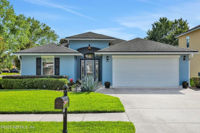 a front view of a house with a yard and potted plants