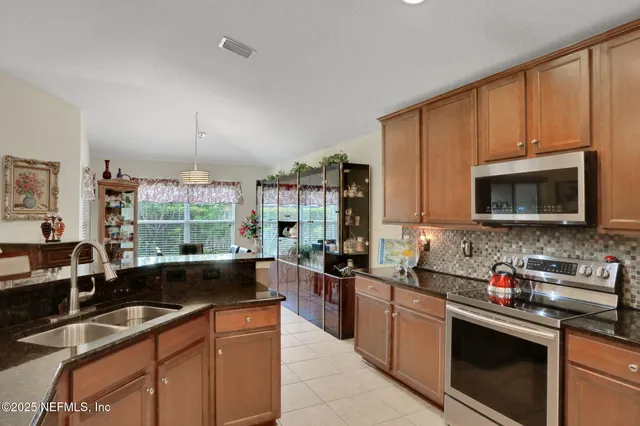 a kitchen with stainless steel appliances granite countertop a sink and a stove