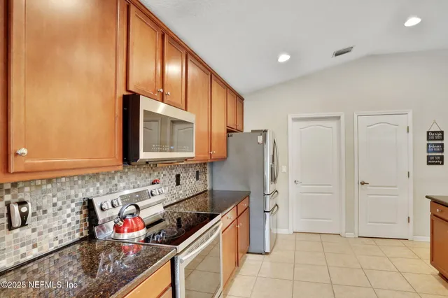 a kitchen with stainless steel appliances granite countertop a refrigerator and a sink