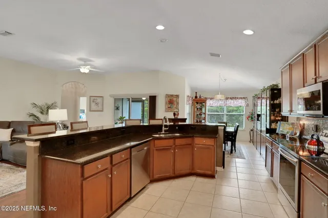 a kitchen with stainless steel appliances granite countertop a sink stove and microwave