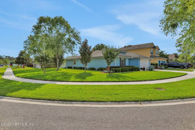 a front view of a house with a yard and potted plants