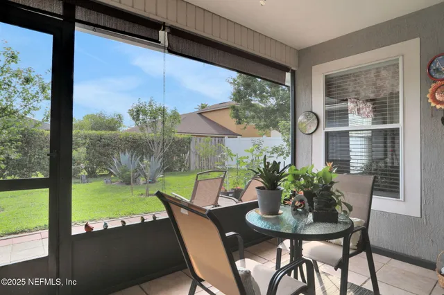 a roof deck with table and chairs and potted plants