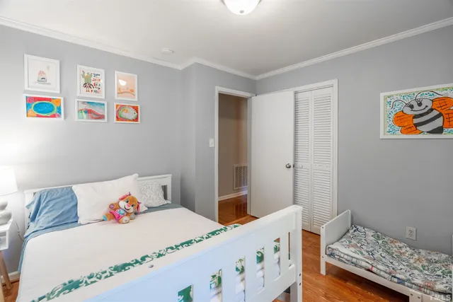 a bedroom with a bed and painting on the wall