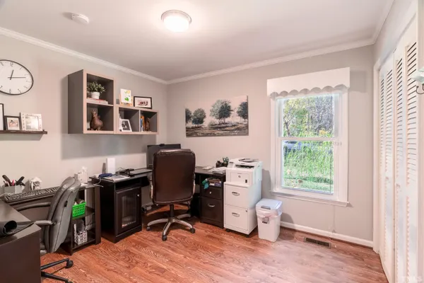 a view of a workspace with furniture and a window