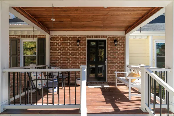 a view of a porch with wooden floor and furniture