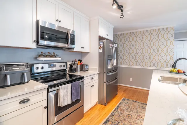 a kitchen with stainless steel appliances a stove microwave and refrigerator