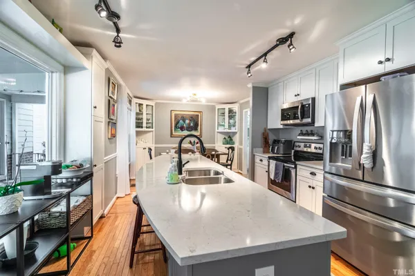 a kitchen with stainless steel appliances granite countertop a sink a stove and a refrigerator