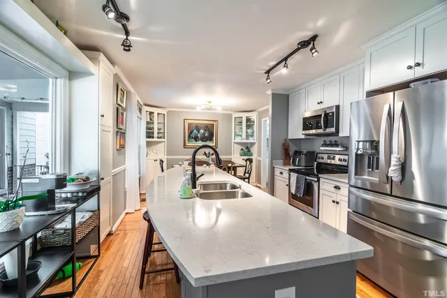 a kitchen with stainless steel appliances granite countertop a sink a stove and a refrigerator