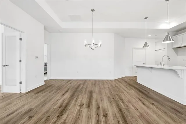 a view of a room with wooden floor and kitchen view