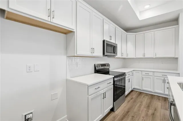 a kitchen with granite countertop white cabinets sink and stainless steel appliances