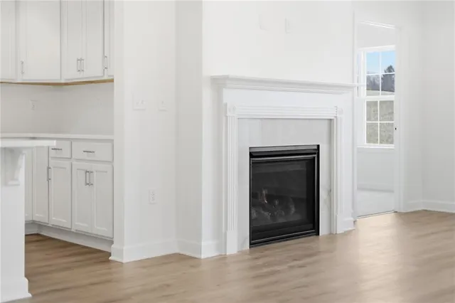 a view of a livingroom with wooden floor and a fireplace