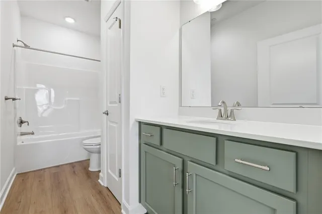 a bathroom with a bathtub shower sink vanity and toilet