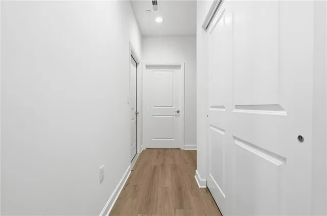 a view of a hallway with wooden floor