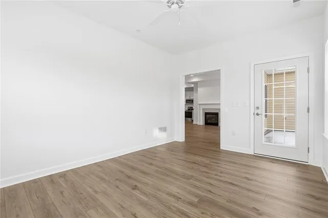 a view of empty room with wooden floor and fireplace