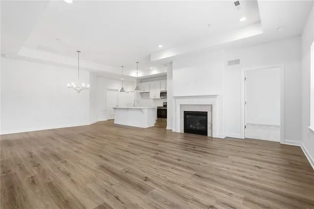 a view of empty room with wooden floor and fireplace